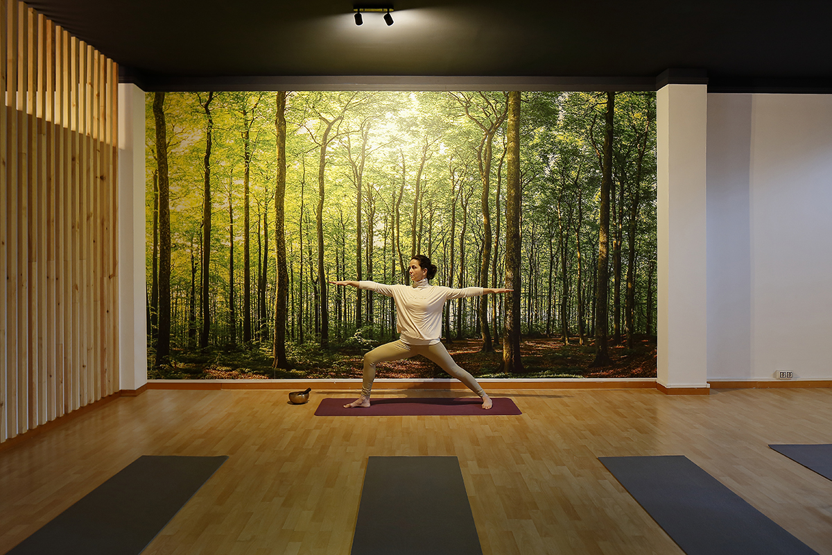 Persona impartiendo una clase en la sala de entrenamiento tras un trabajo de interiorismo en un centro de yoga