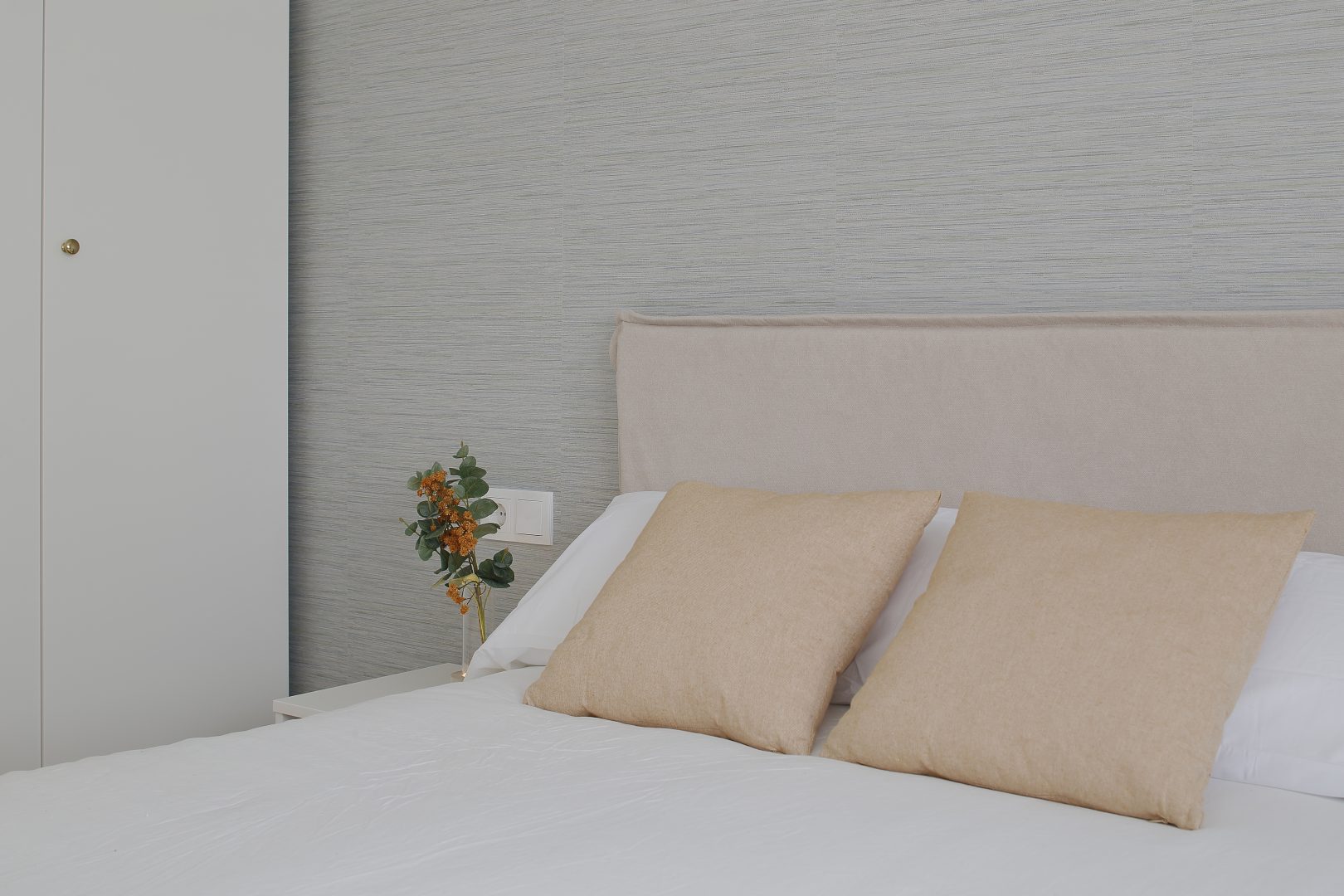 Cabecero de cama y cojines de dormitorio diseñado en proyecto de interiorismo