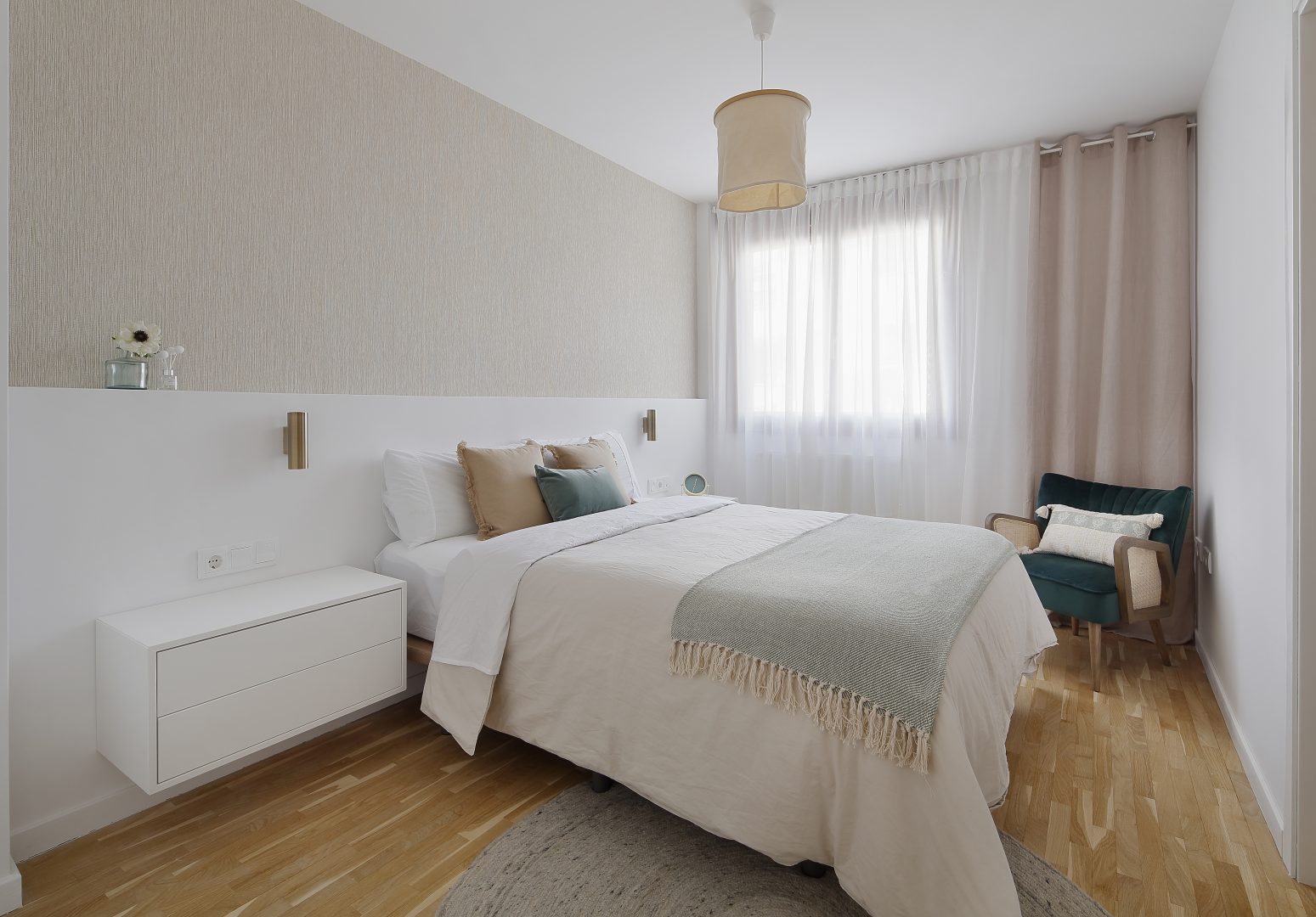 Dormitorio principal con butaca verde diseñado en proyecto de interiorismo