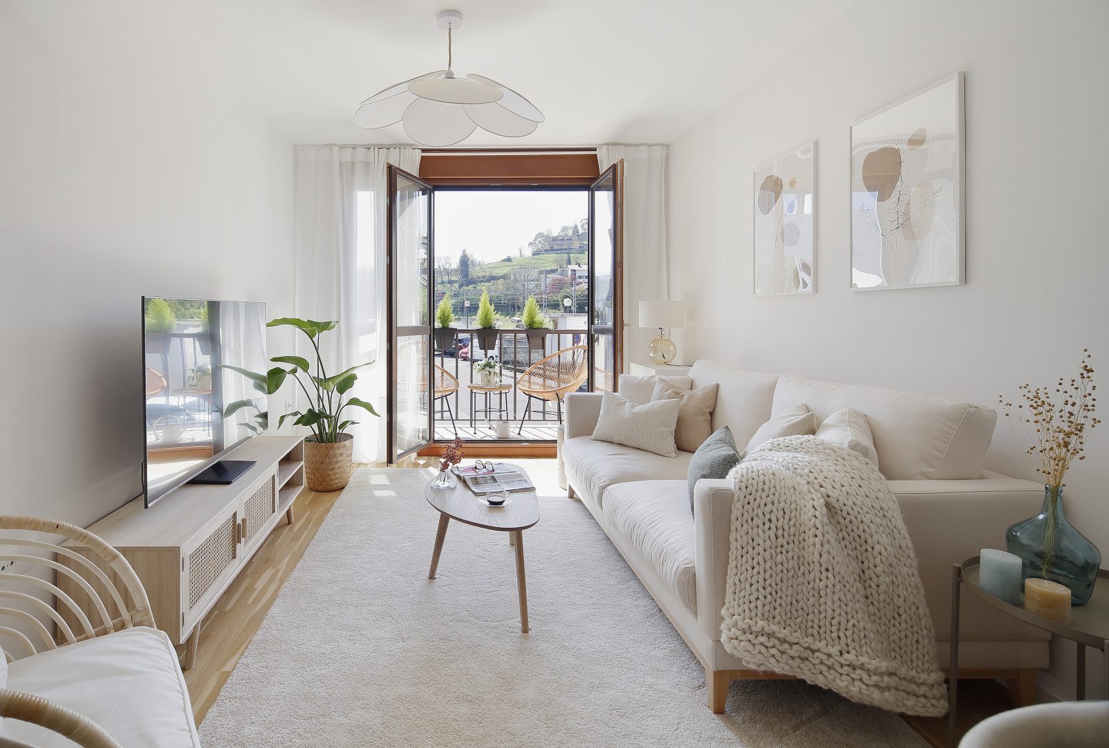 Espacio de sofá en salón diseñado en proyecto de interiorismo con balcón abierto al fondo