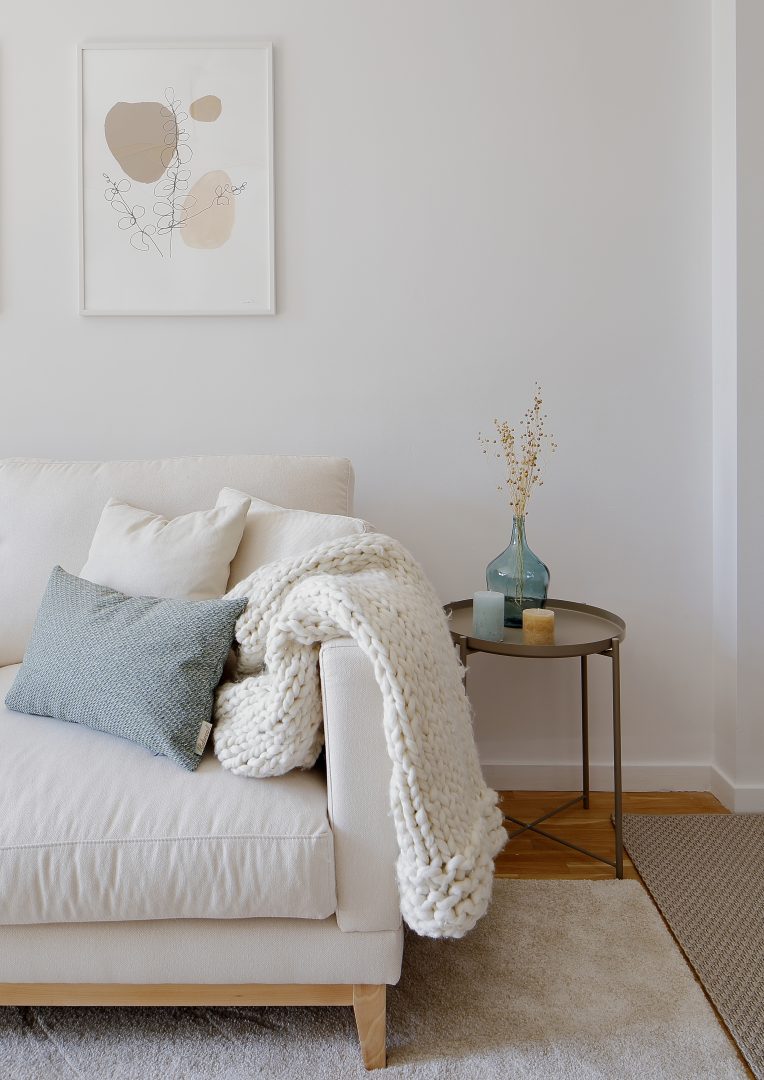 Rincón de mesita junto al sofá de un salón diseñado en proyecto de interiorismo